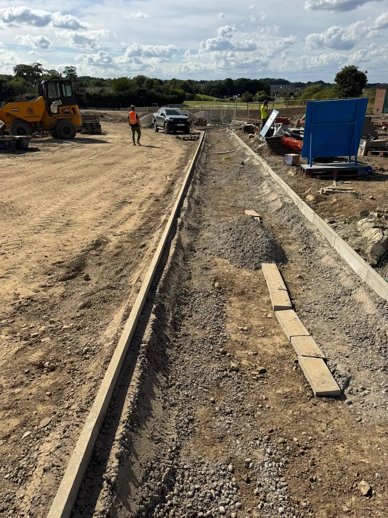 Precision kerb installation along a prepared groundwork channel